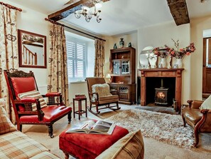 A traditional living room with a fireplace, leather furniture, and a bookshelf. - 1 Bed in Penrith (oc-91812) (Ullswater)