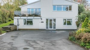 Ein zweistöckiges Gebäude mit Balkon, Garage und Auffahrt.