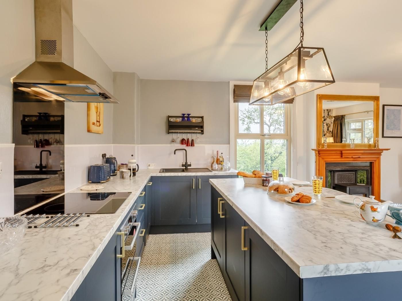 Une cuisine moderne dotée d’un grand îlot central, d’un four encastré et d’une cuisinière à gaz.