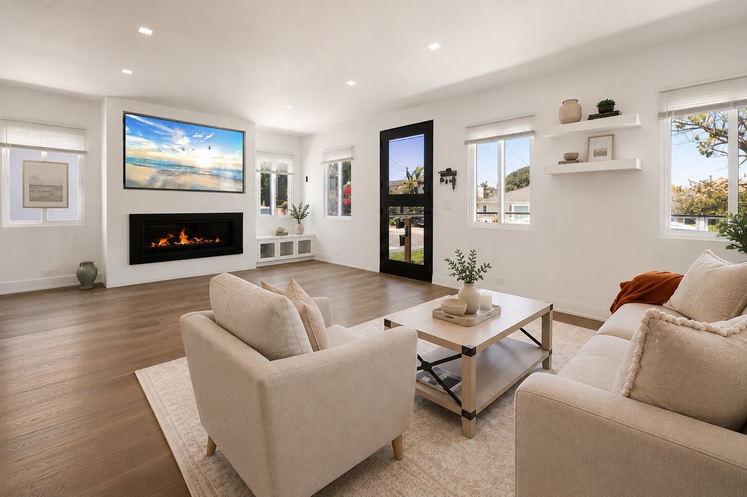 Una sala de estar moderna con chimenea, asientos cómodos y un televisor grande.