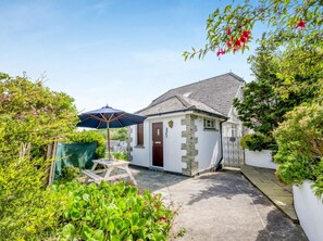 A small white building with a stone staircase, a wooden door, and a blue umbrella. - 2 Bed in Fowey (oc-92080) (Fowey)