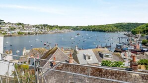 A coastal town with a harbor filled with boats, houses with sloped roofs, and a clear sky. - 2 Bed in Fowey (oc-92080) (Fowey)