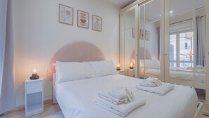 A hotel room with a bed, bedside lamps, a wardrobe with mirrors, and artwork on the wall. - 2-bedroom apartment • St. Paul's Basilica • Metro B, 600 meters • A/C (Roma)
