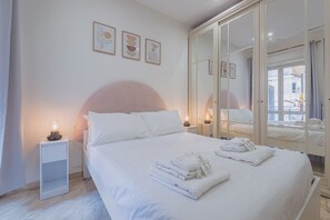 A hotel room with a bed, bedside lamps, a wardrobe with mirrors, and artwork on the wall. - 2-bedroom apartment • St. Paul's Basilica • Metro B, 600 meters • A/C (Roma)