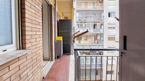 A narrow balcony with a brick wall on one side and a metal railing on the other, overlooking a multi-story residential building. - 2-bedroom apartment • St. Paul's Basilica • Metro B, 600 meters • A/C (Roma)