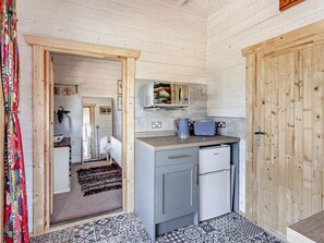 Una cocina compacta con refrigerador, microondas y tostadora.