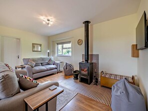 A cozy living room with a sofa, a table, a fireplace, and a window. - 2 Bed in Ripon (oc-91955) (West Tanfield)