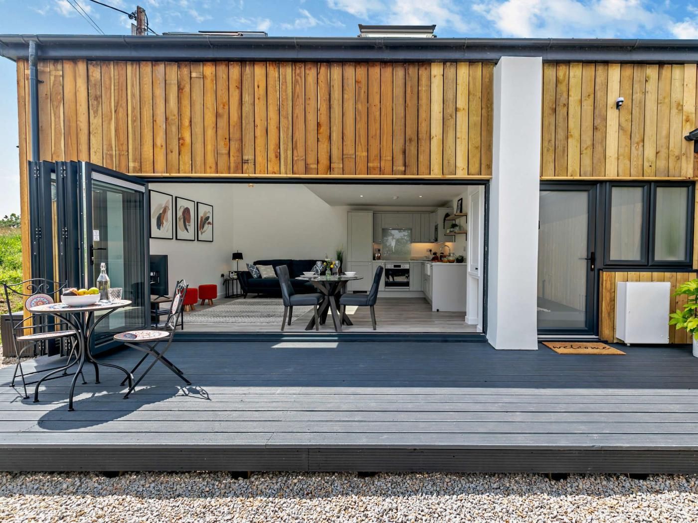 A modern house with a deck, a dining area, and a kitchen.