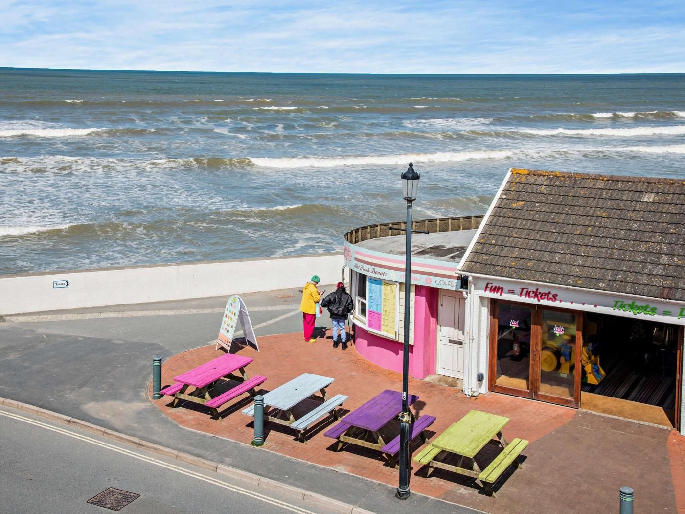 Un café en bord de mer avec une terrasse et vue sur l’océan.