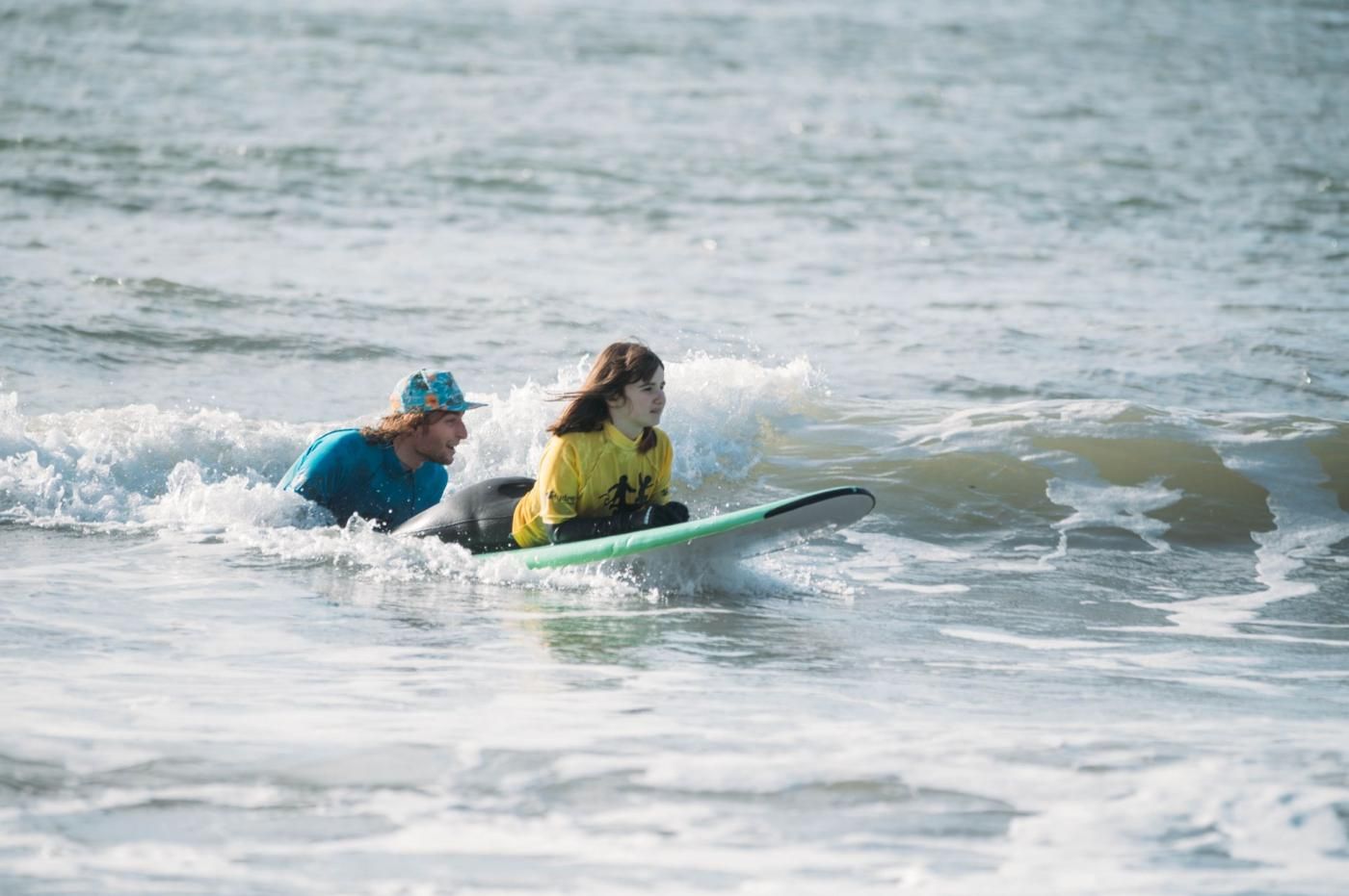 Two individuals on a surfboard in the ocean.