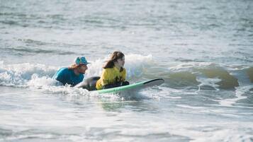 Two individuals on a surfboard in the ocean.