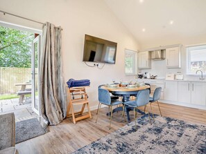 A modern kitchen with a dining area, wooden flooring, and a large window. - 2 Bed in Swansea (oc-91728) (Upper Killay)