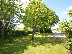 A tree-lined pathway with a grassy area and a road in the background. - 2 Bed in Alford (oc-92399) (Huttoft)