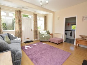 A living room with a sofa, a green chair, a pink ottoman, and a purple rug. - 2 Bed in Alford (oc-92399) (Huttoft)