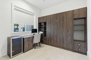 Un espace de bureau moderne comprenant un bureau, une chaise et des étagères intégrées.