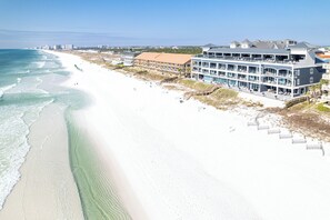 Ett hotell vid stranden med flera balkonger, en sandstrand och utsikt över havet.