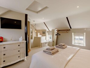 A bedroom with a bed, dresser, mirror, and a TV mounted on the wall. - 1 Bed in Stamford (oc-92406) (Ketton)