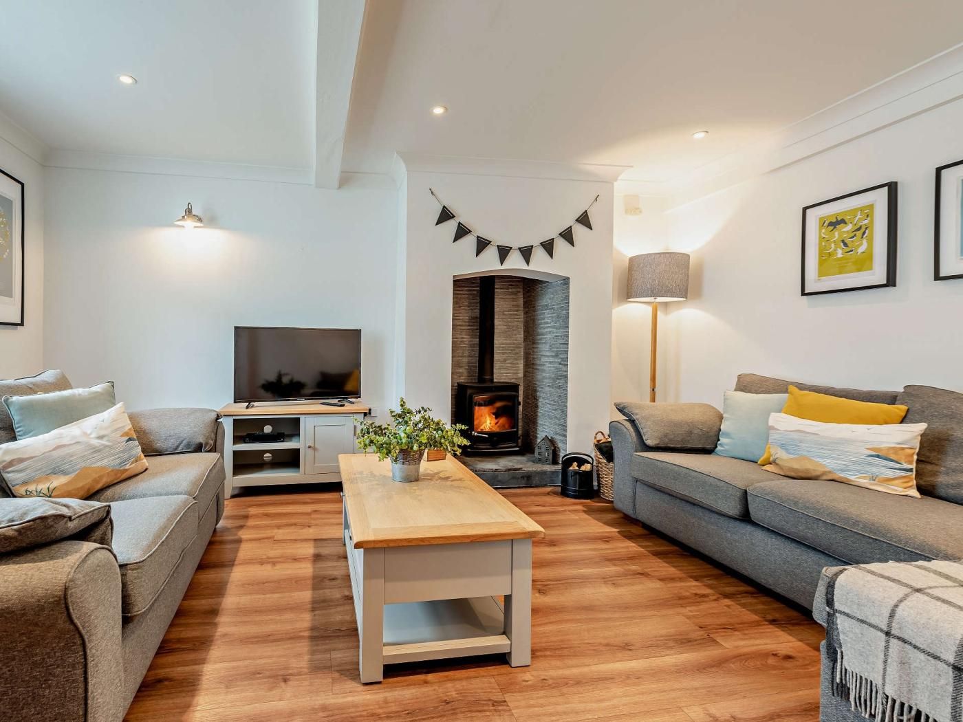 A modern living room with a fireplace, a sofa, a coffee table, and a television.