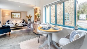 Ein stilvolles Wohnzimmer mit einer Couch, einem Sessel und einem Tisch mit Teeservice.