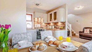 Une cuisine moderne avec un coin repas, un canapé et une table mise pour le petit-déjeuner.