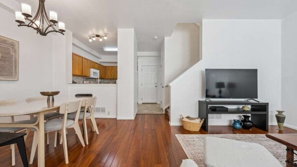 A modern apartment with a dining area, kitchen, living room, and staircase. - Spacious 3BR Home w/Garage - Easy DIA Access (Commerce City)