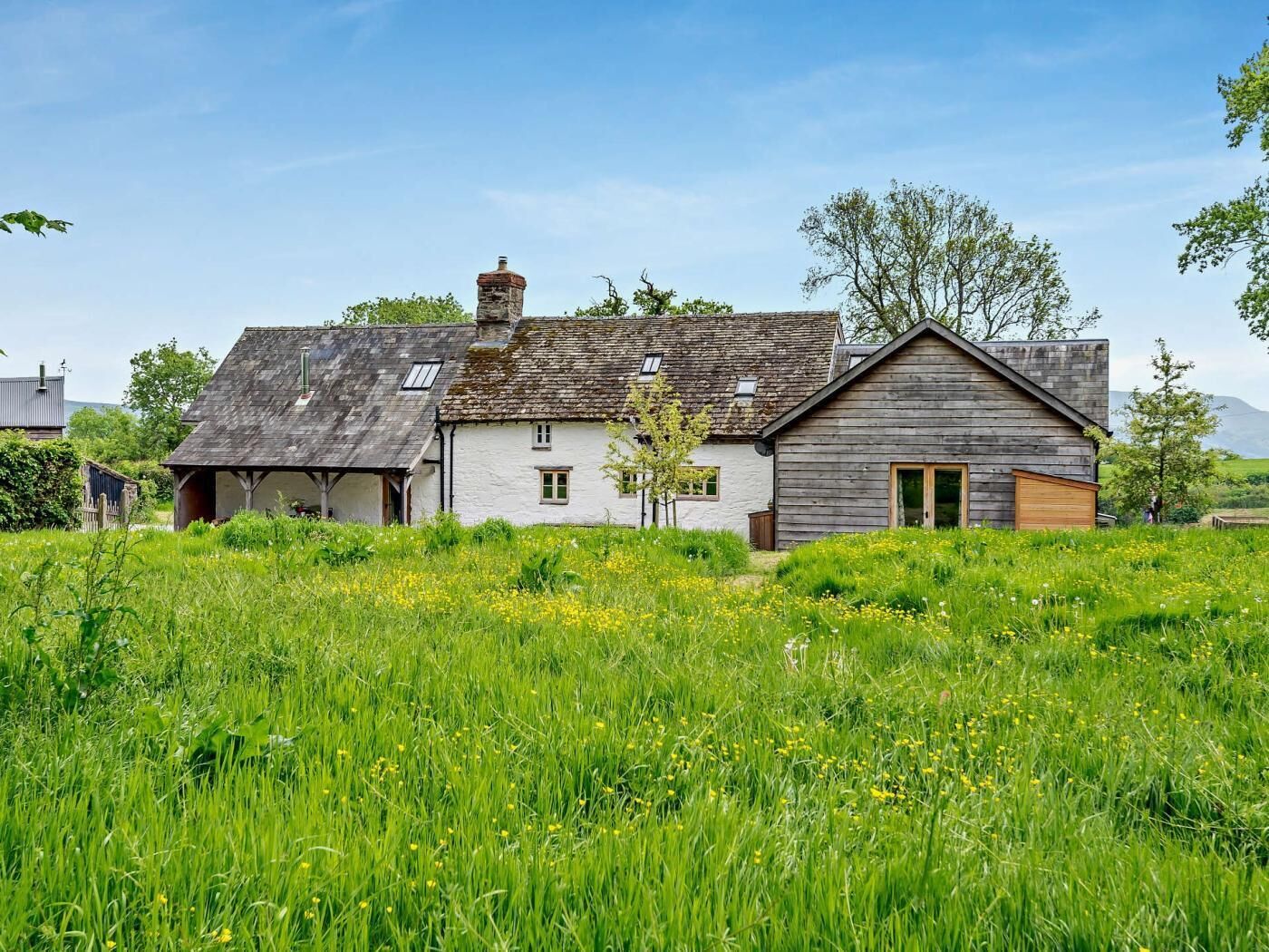 A traditional house with a sloped roof, a chimney, and a small porch.