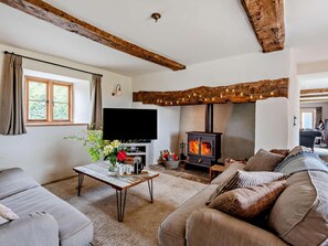 A living room with a fireplace, a sofa, a coffee table, and a television.
