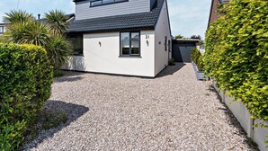 Een modern herenhuis met grindpad, garage en verzorgde tuin.