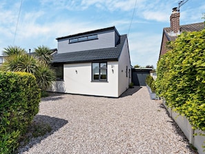 A modern two-story house with a gravel driveway, a garage, and a well-maintained garden. - 2 Bed in Poulton-le-fylde (oc-92095) (Knott End-on-Sea)