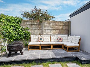A corner outdoor seating area with a stone bench and a grill. - 2 Bed in Poulton-le-fylde (oc-92095) (Knott End-on-Sea)
