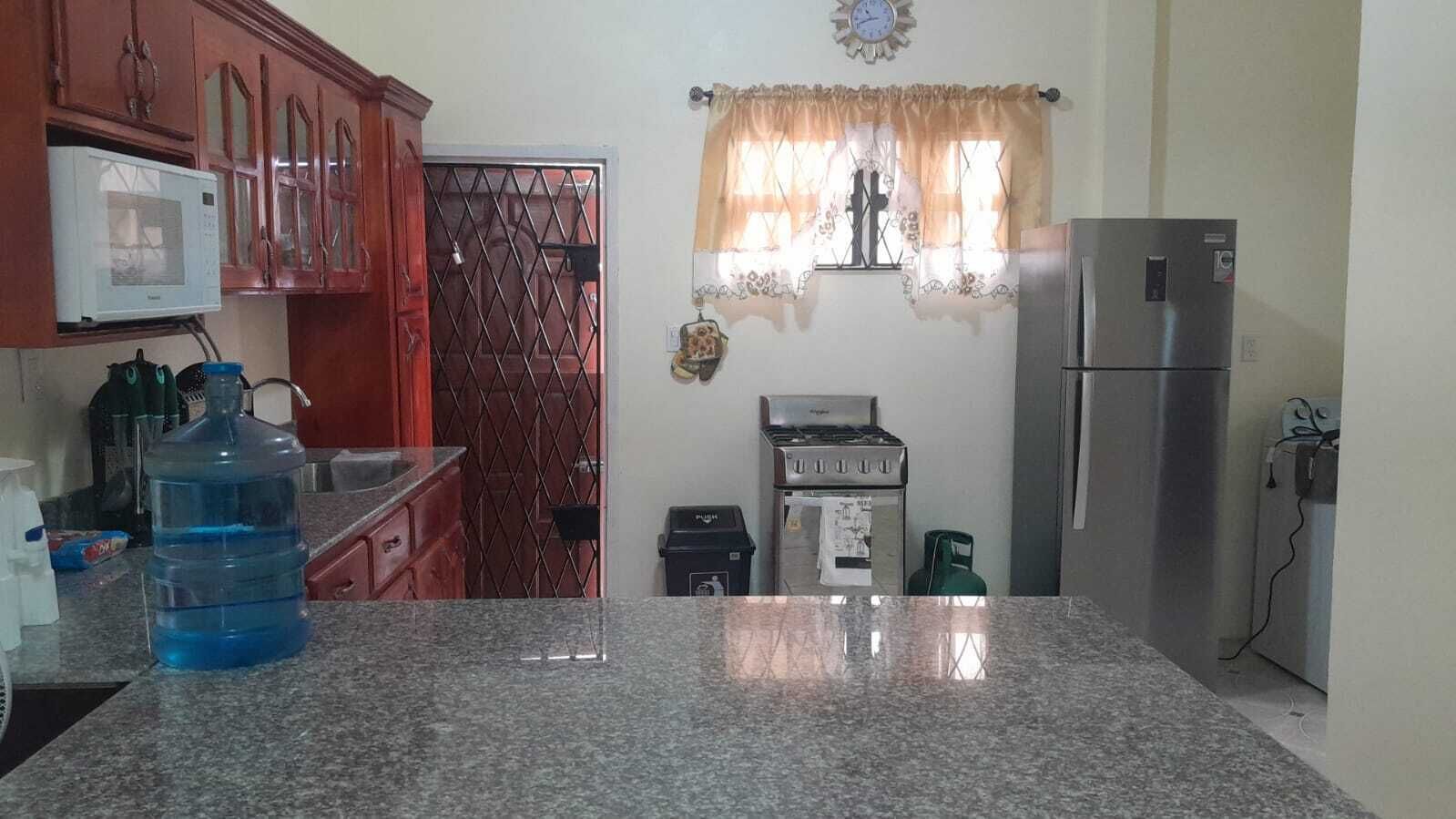 A kitchen with granite countertops, a stainless steel refrigerator, a gas stove, and a microwave.