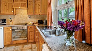 A kitchen with wooden cabinets, a stove, a microwave, a toaster, and a sink. - 2 Bed in Alford (oc-92252) (Rigsby)