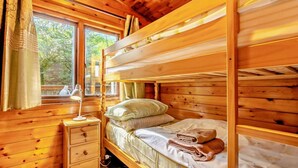A wooden cabin room with bunk beds, a bedside table, and a window with curtains. - 2 Bed in Ambleside (oc-92240) (Grasmere)