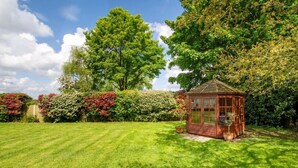 A well-maintained garden with a gazebo, lush green lawn, and various shrubs. - 1 Bed in Norwich (oc-92295) (Strumpshaw)