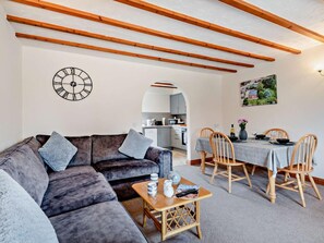 A modern living room with a sofa, a coffee table, and a dining area with chairs and a table. - 2 Bed in Dereham (oc-92392) (Horningtoft)