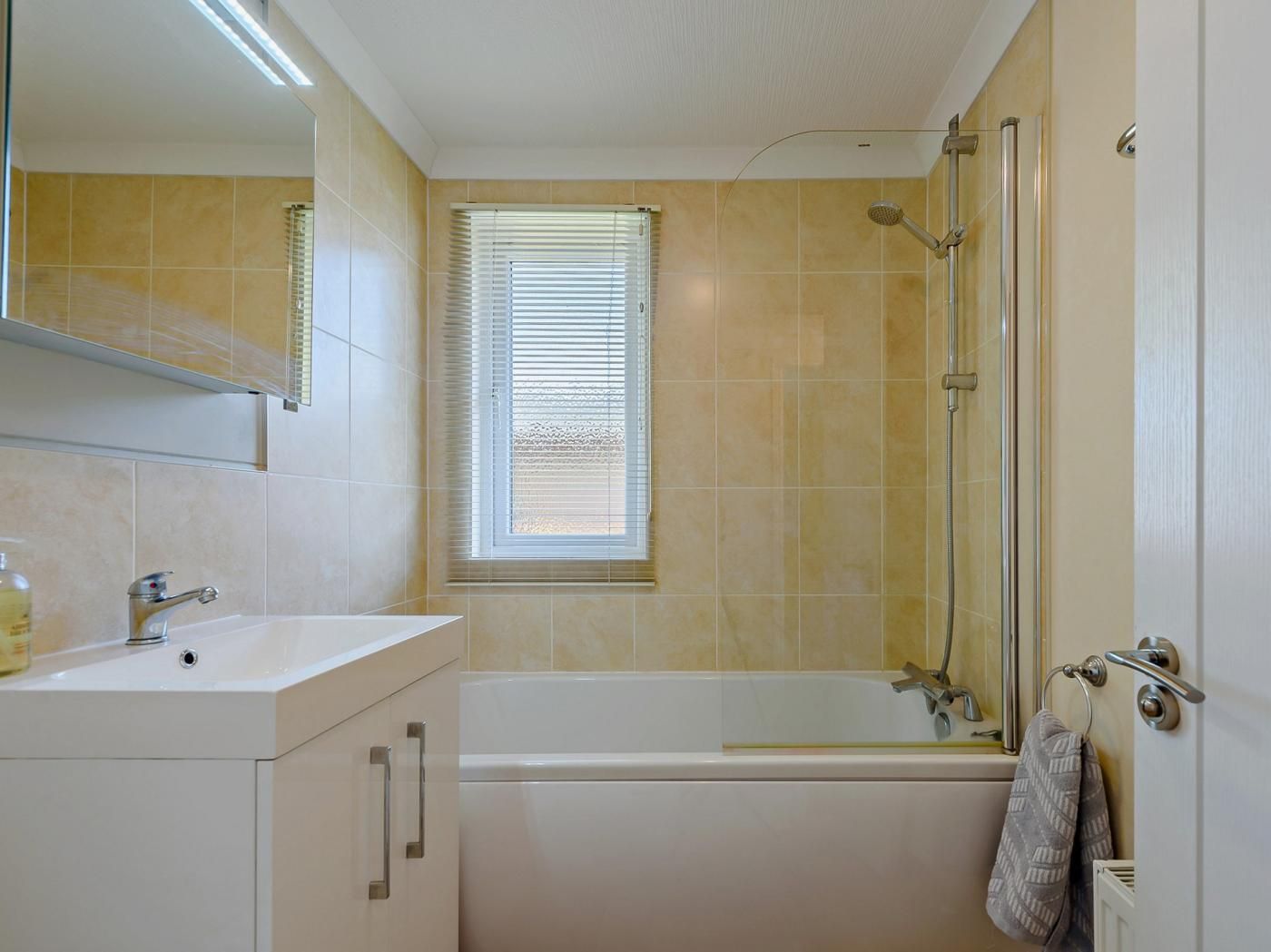 Un baño con bañera, lavabo, espejo y ducha.