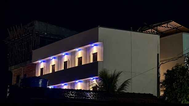 A modern two-story building with illuminated windows and a flat roof.
