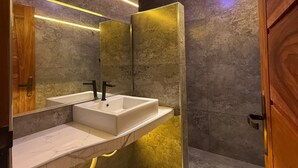 A modern bathroom with a dual sink vanity, a mirror, and a recessed ceiling light.
