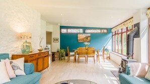 A living room with a teal wall, wooden furniture, a glass coffee table, and a fireplace. - 2 Bed in Buxton (oc-91974) (Wormhill)