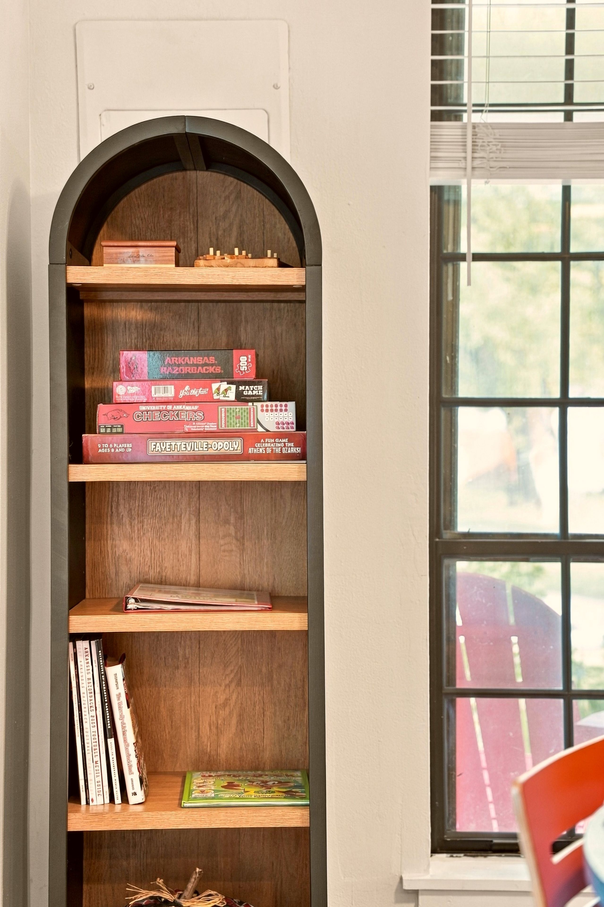 A bookshelf with various board games and books.