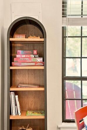 A bookshelf with various board games and books.