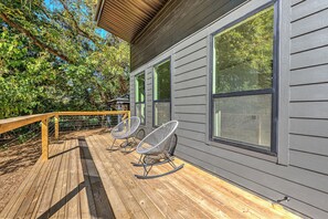 Eine Holzterrasse mit Schaukelstühlen und einem Hollerker.