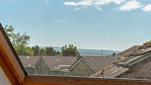 A view through a skylight of residential buildings with sloped roofs and a clear sky. - 4 Bed in Alston (oc-92351) (Alston)