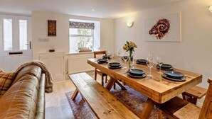A dining area with a wooden table set for four, a bench, and a view of the outdoors through a window. - 4 Bed in Alston (oc-92351) (Alston)