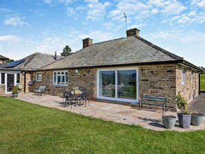 A stone cottage with a patio, a dining table, and chairs. - 2 Bed in Otley (oc-92378) (Leathley)