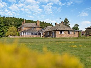 A large stone building with multiple rooms, a covered patio, and a grassy field in the foreground. - 2 Bed in Otley (oc-92378) (Leathley)