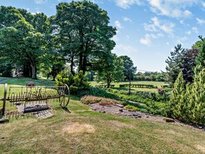 A garden with a metal fence, trees, and a clear sky. - 3 Bed in Pickering (oc-92356) (Cropton)