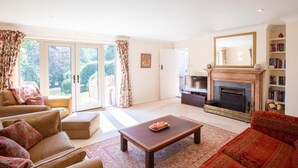 Ein geräumiges Wohnzimmer mit Sofa, Couchtisch, Kamin und Bücherregal.