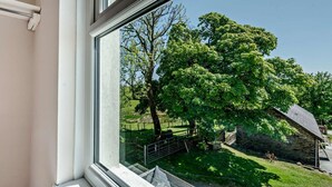 A window with a view of a green landscape, a stone building, and a metal fence. - 3 Bed in Carmarthen (oc-92116) (Gwernogle)