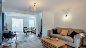 Un salón amplio con sofá, mesa de centro y chimenea.